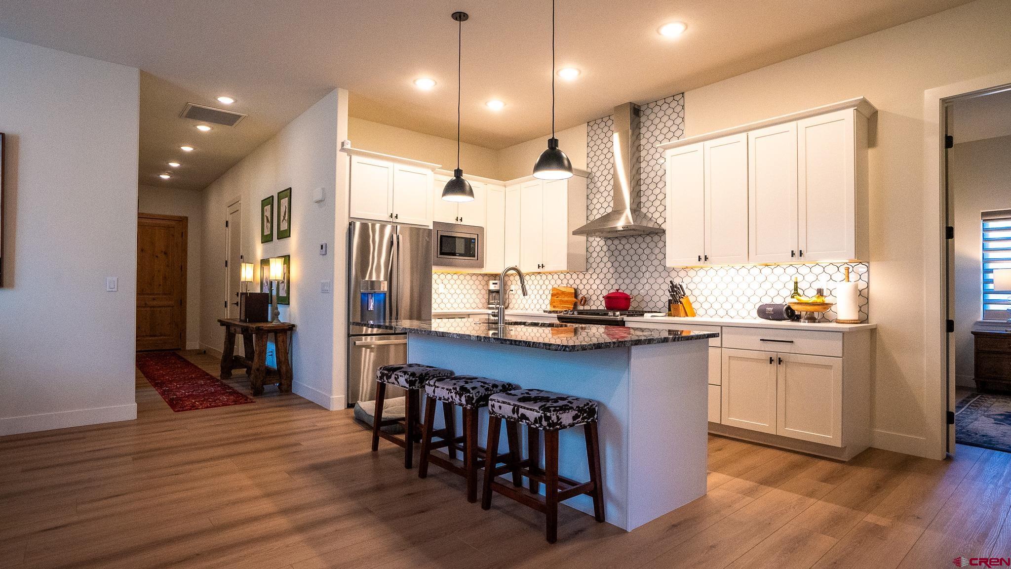 236 Via Tuscana Durango, CO 81301 - Photo 6 of 31 a kitchen with kitchen island granite countertop a sink a center island and stainless steel appliances