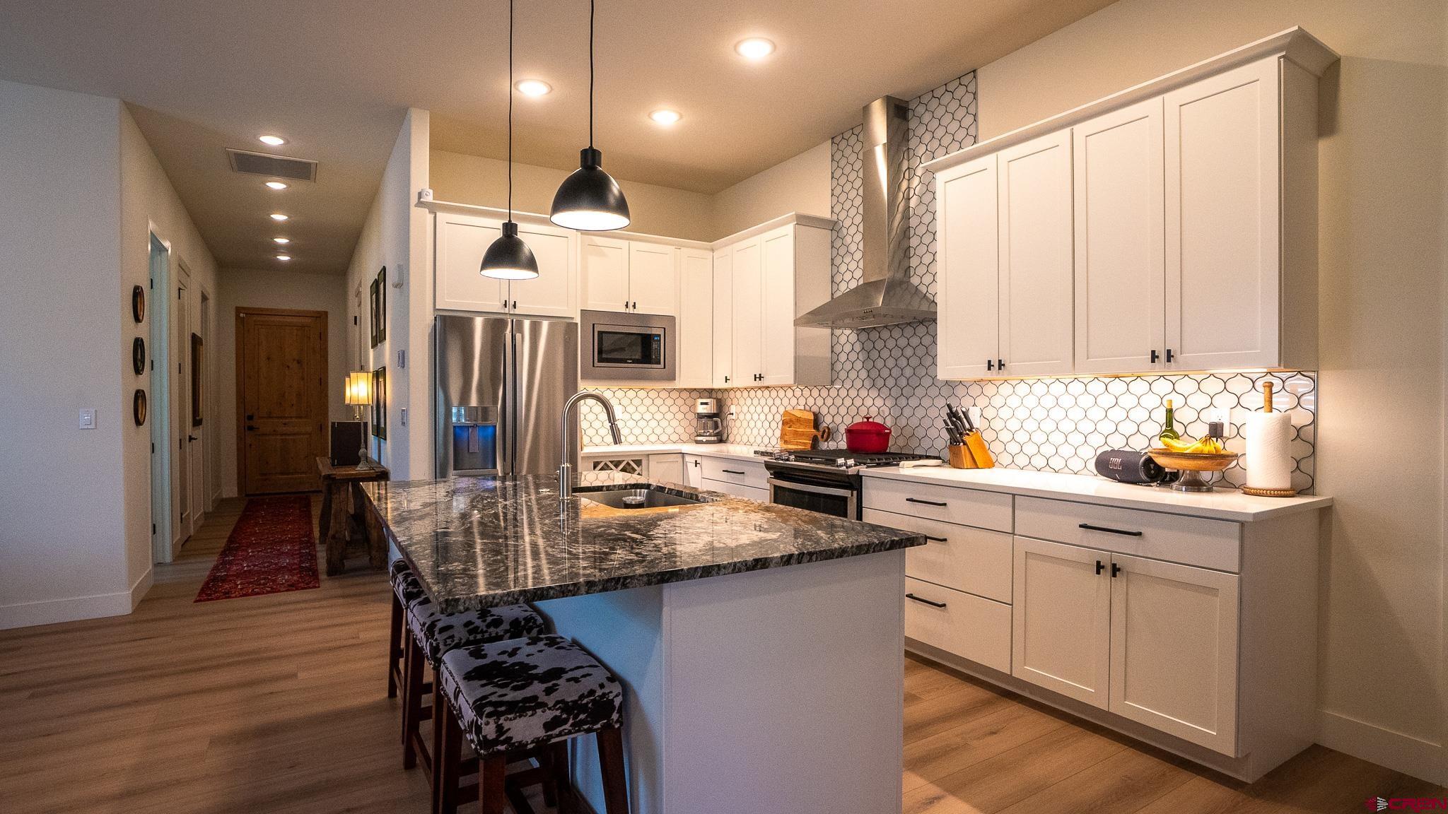 236 Via Tuscana Durango, CO 81301 - Photo 7 of 31 a kitchen with a table chairs stove and cabinets