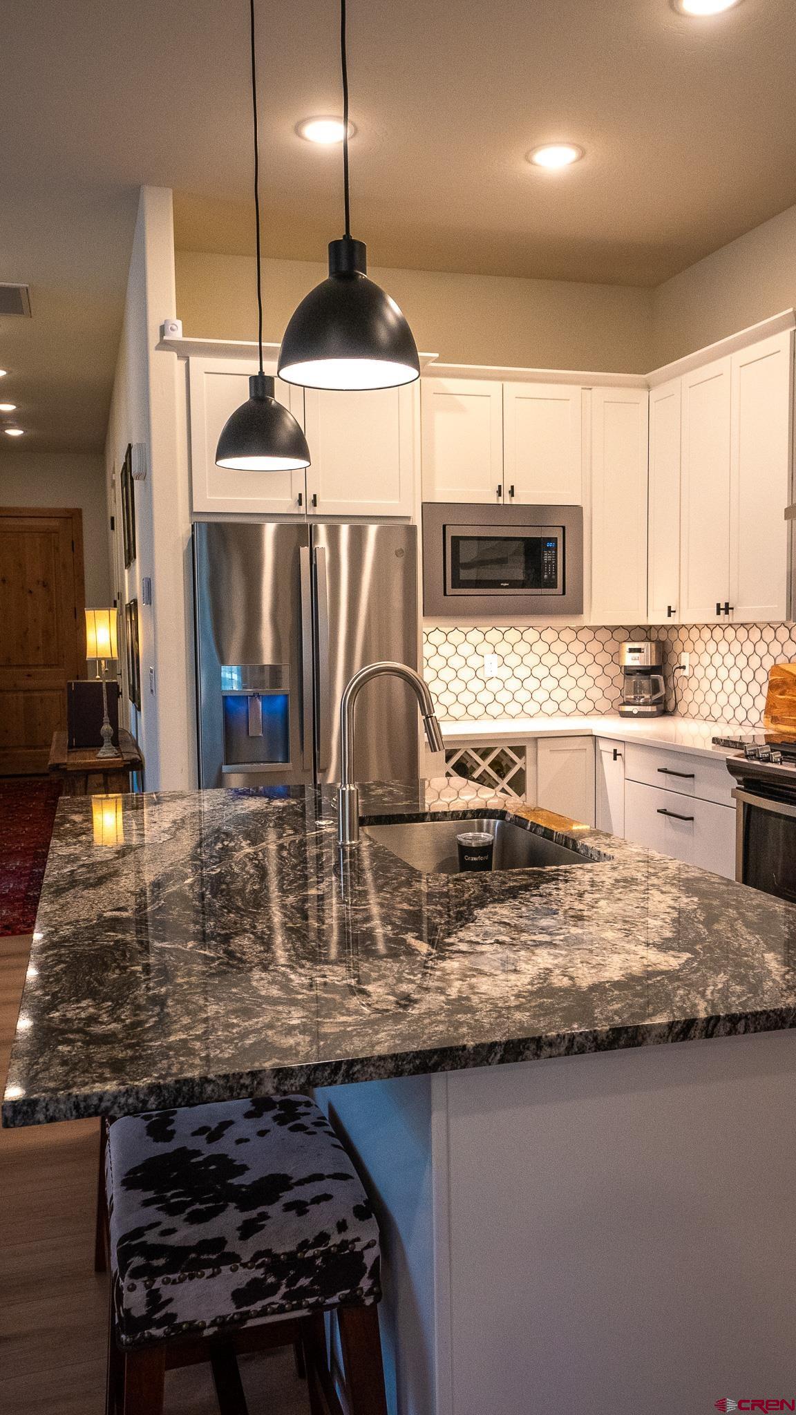236 Via Tuscana Durango, CO 81301 - Photo 8 of 31 a kitchen with kitchen island granite countertop a stove and a sink