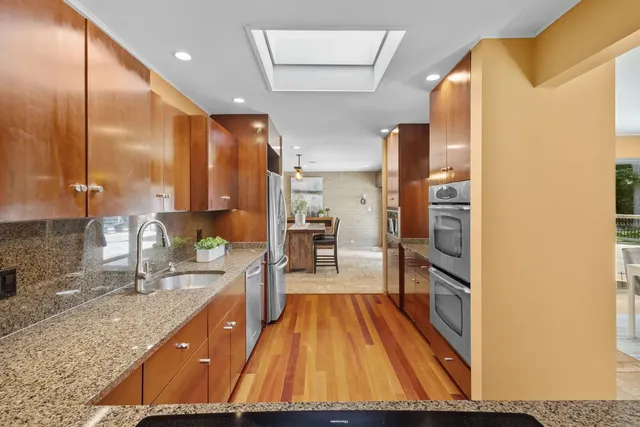 a spacious bathroom with a granite countertop sink a large mirror and shower