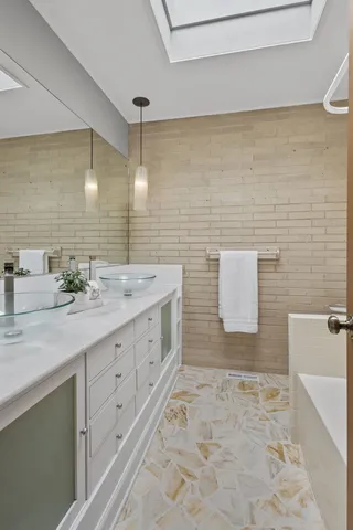 a bathroom with a sink a toilet and mirror