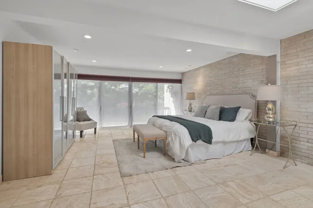 a spacious bedroom with a large bed and a large window