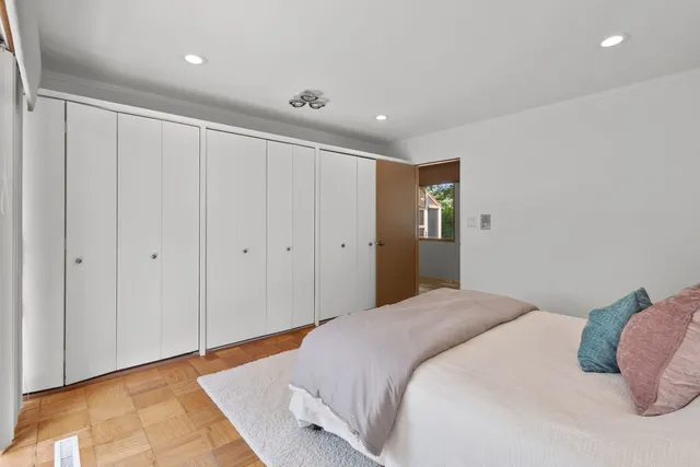 a spacious bedroom with a bed and a painting