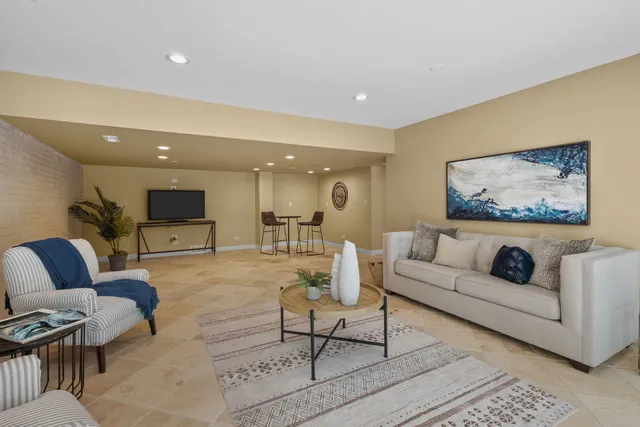 a living room with furniture and a floor to ceiling window