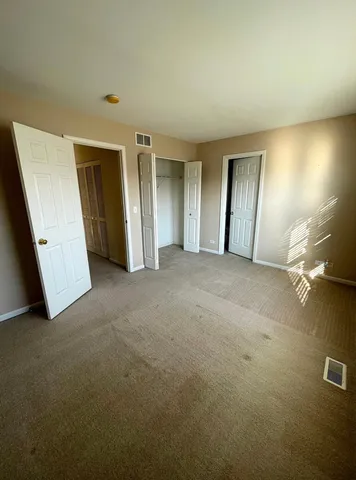 an empty room with windows and closet