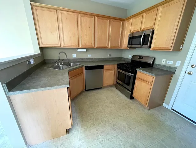 a kitchen with stainless steel appliances granite countertop a stove a sink and a microwave