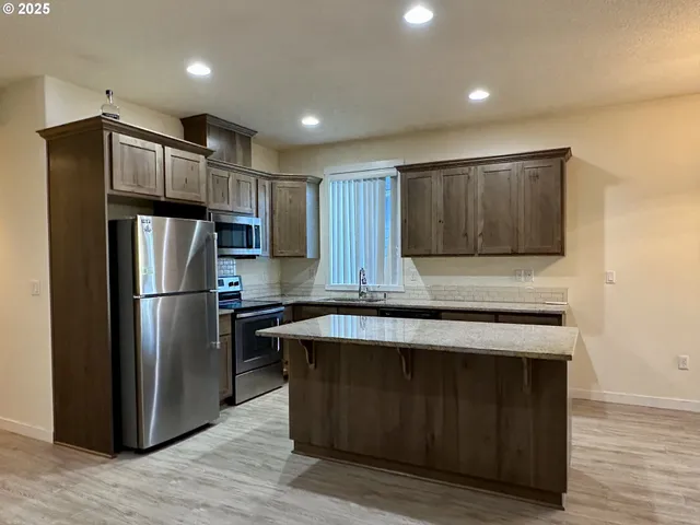 a kitchen with wooden cabinets and stainless steel appliances
