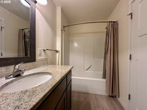 a bathroom with a granite countertop sink mirror and shower