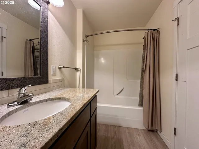 a bathroom with a granite countertop sink mirror and shower