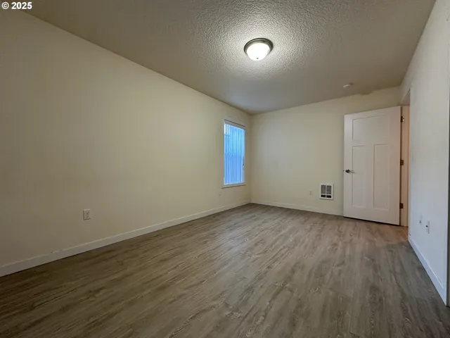 a view of an empty room and wooden floor