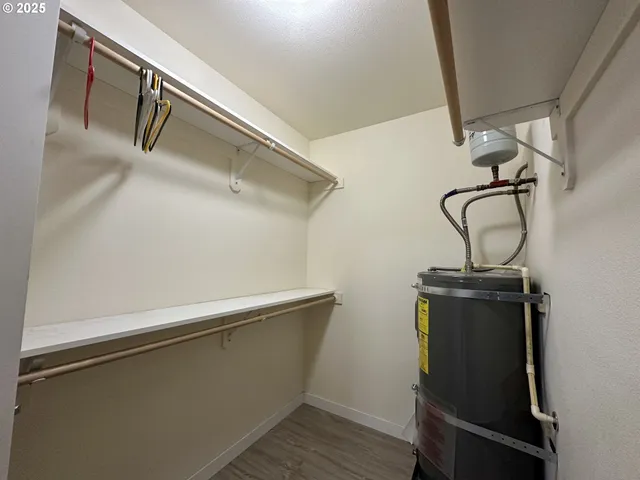 a view of a storage and utility room with wooden floor