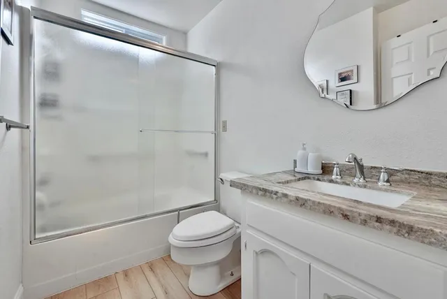 a bathroom with a granite countertop sink toilet and shower