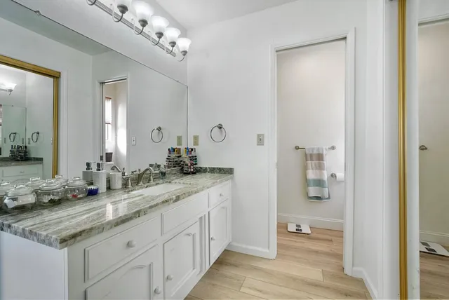 a bathroom with a granite countertop sink and a mirror