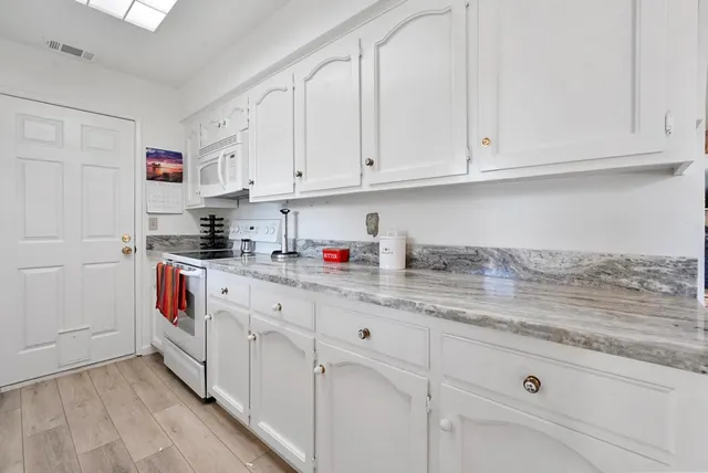 a kitchen with white cabinets and white appliances