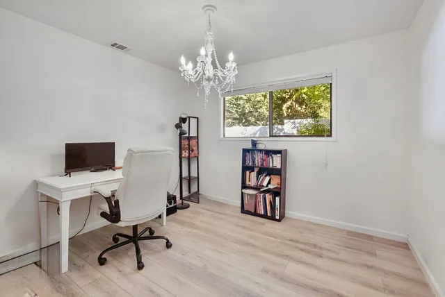 a view of a workspace with furniture and a window