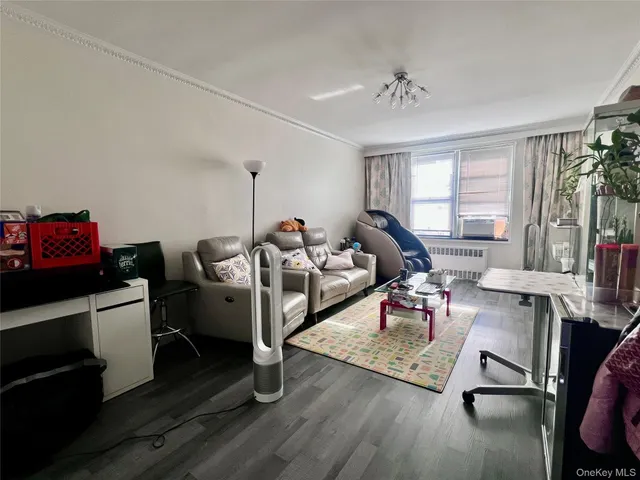 a living room with furniture hard wood floor and a window