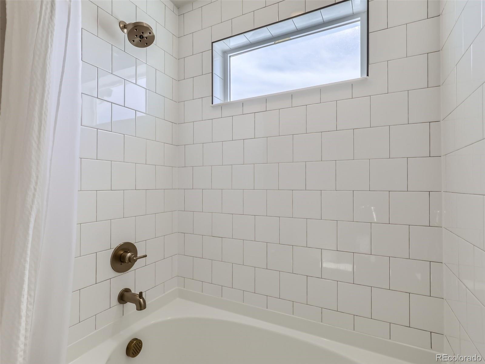 4495 Riviera Court Aurora, CO 80019 - Photo 16 of 28 a bathroom with a bathtub