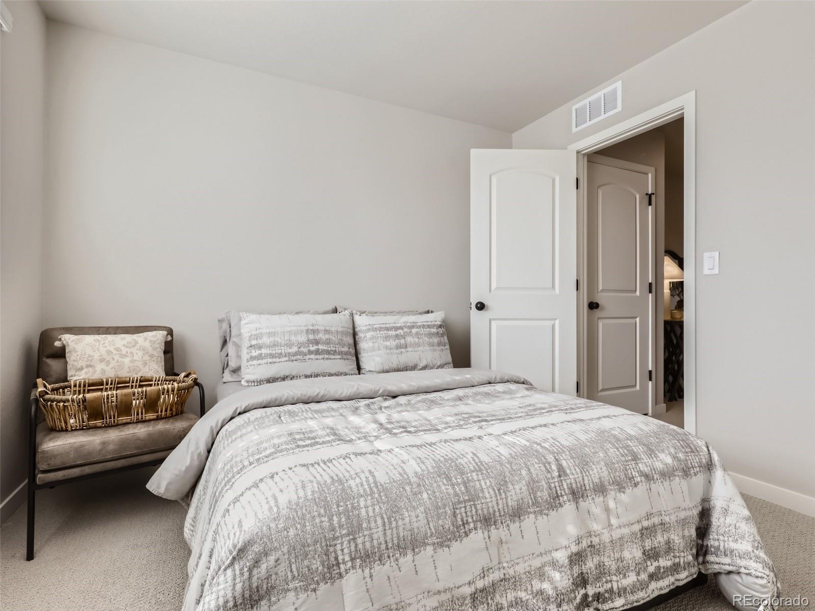 4495 Riviera Court Aurora, CO 80019 - Photo 18 of 28 a bedroom with a bed and a view of bathroom
