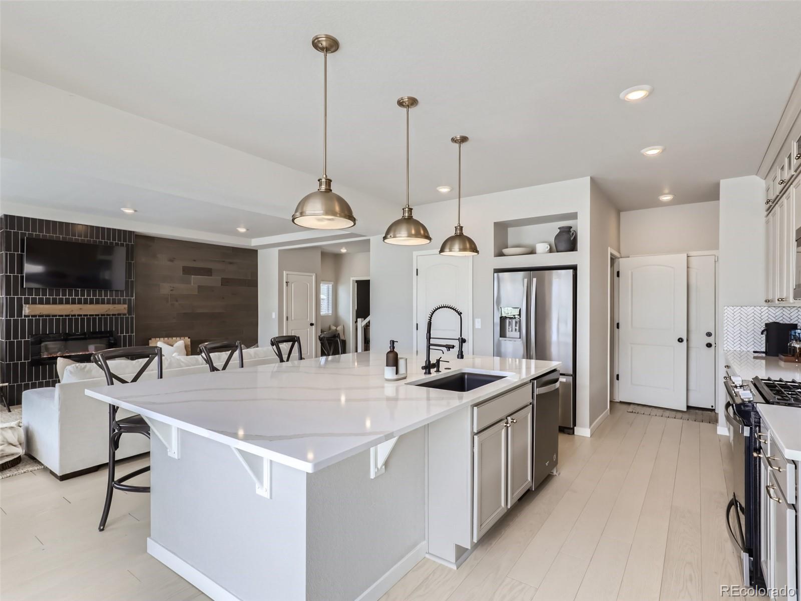 4495 Riviera Court Aurora, CO 80019 - Photo 3 of 28 a kitchen with stainless steel appliances granite countertop a sink a stove and a refrigerator