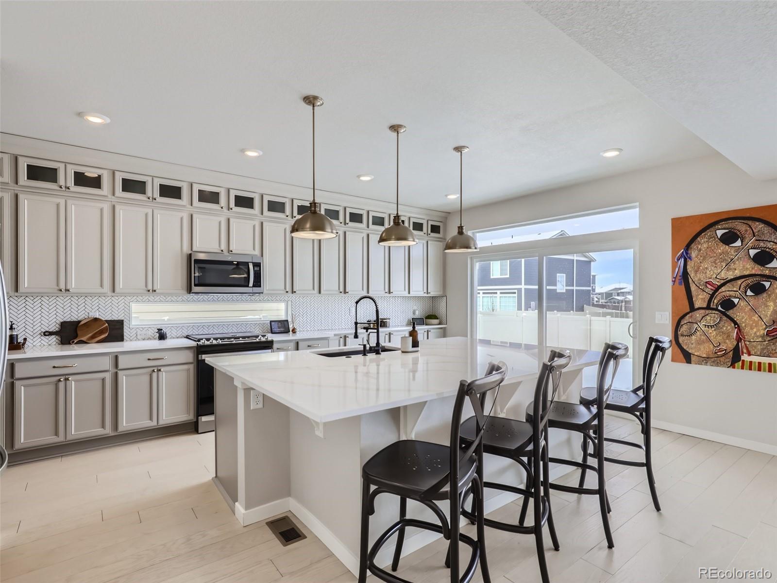 4495 Riviera Court Aurora, CO 80019 - Photo 4 of 28 a kitchen with stainless steel appliances granite countertop a table and chairs in it