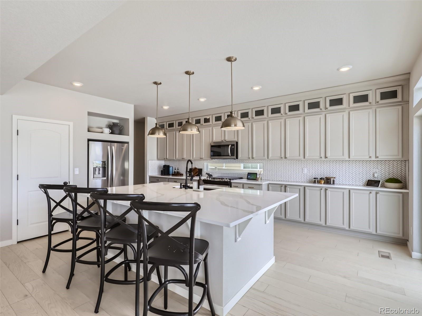 4495 Riviera Court Aurora, CO 80019 - Photo 5 of 28 a kitchen with a table chairs stove and cabinets