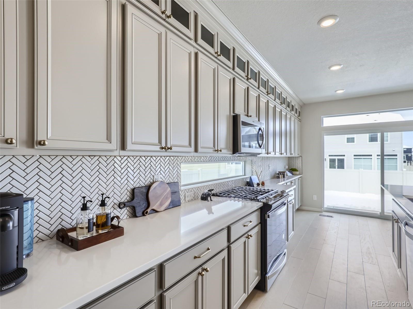 4495 Riviera Court Aurora, CO 80019 - Photo 6 of 28 a kitchen with stainless steel appliances a sink dishwasher stove and cabinets with wooden floor