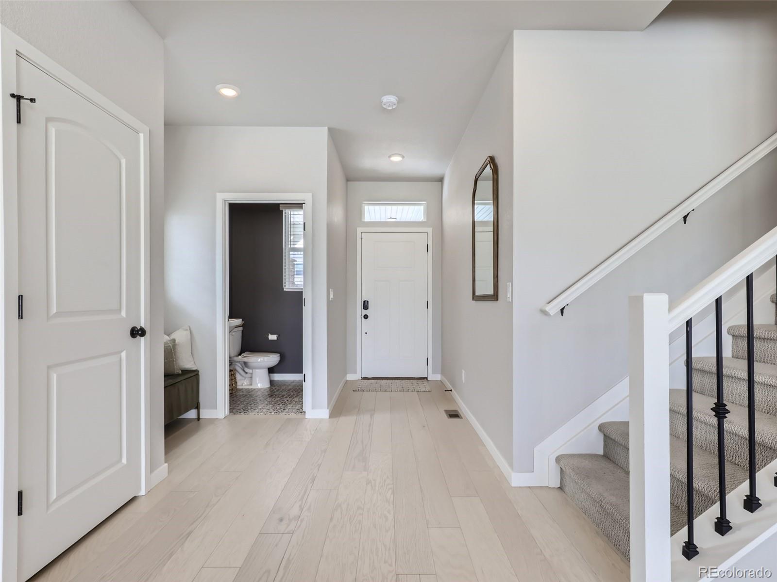 4495 Riviera Court Aurora, CO 80019 - Photo 8 of 28 a view of a hallway with wooden floor and staircase
