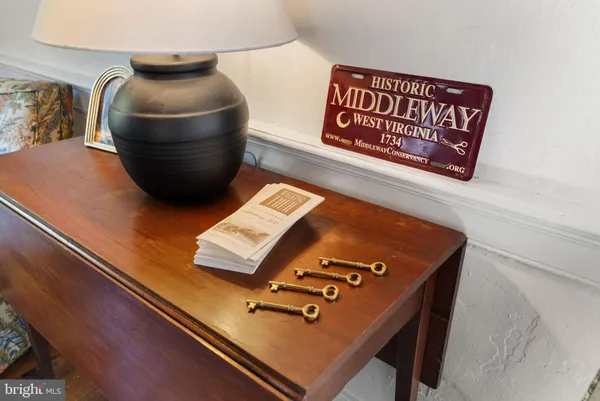 a view of a hallway with wooden floor and stainless steel appliances