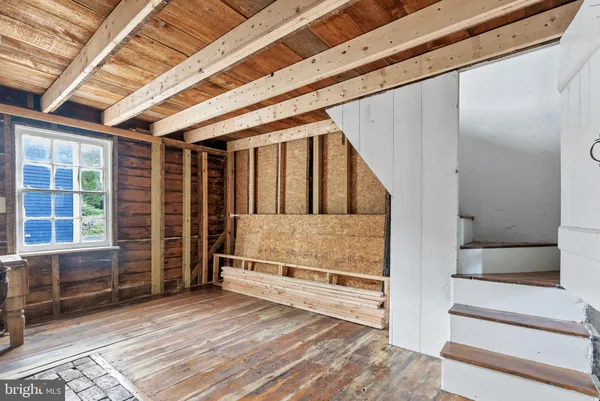 an empty room with wooden floor and white wall