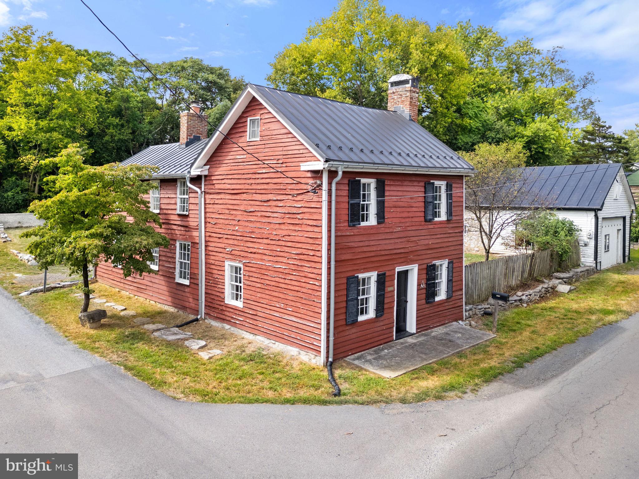 7379 Queen Street Middleway, WV 25430 - Photo 2 of 58 a view of a brick house with a small yard plants and large tree