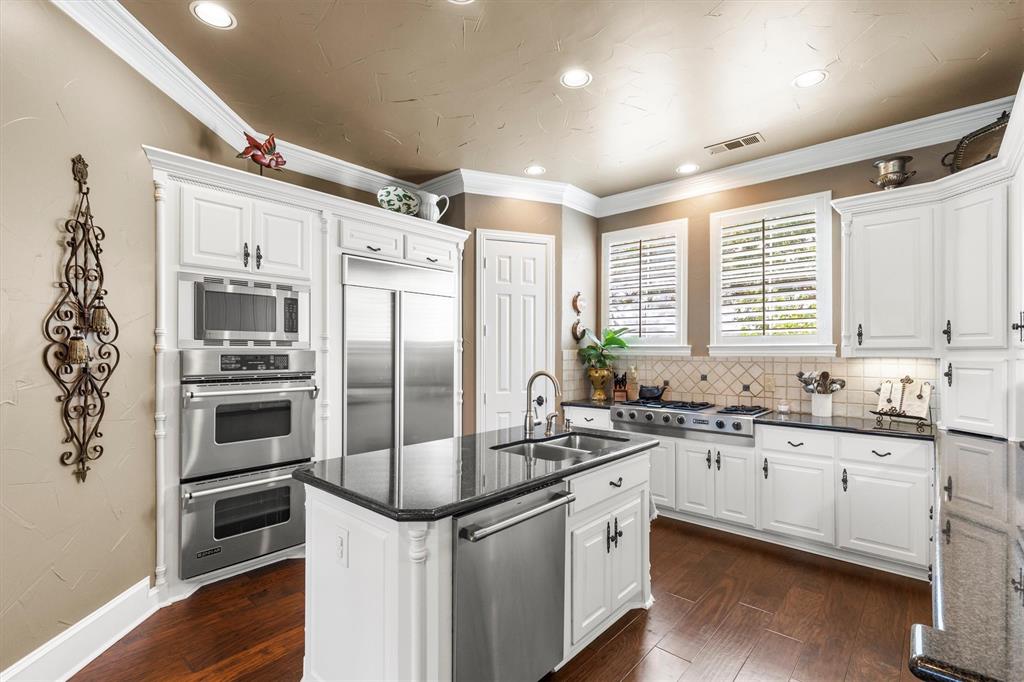 539 Ridge Point Drive Heath, TX 75126 - Photo 13 of 29 a kitchen with granite countertop a sink stainless steel appliances and cabinets