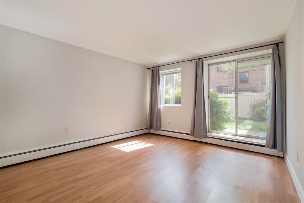 123 Sewall Avenue, Unit LC Brookline, MA 02446 - Photo 29 of 32 an empty room with wooden floor and windows
