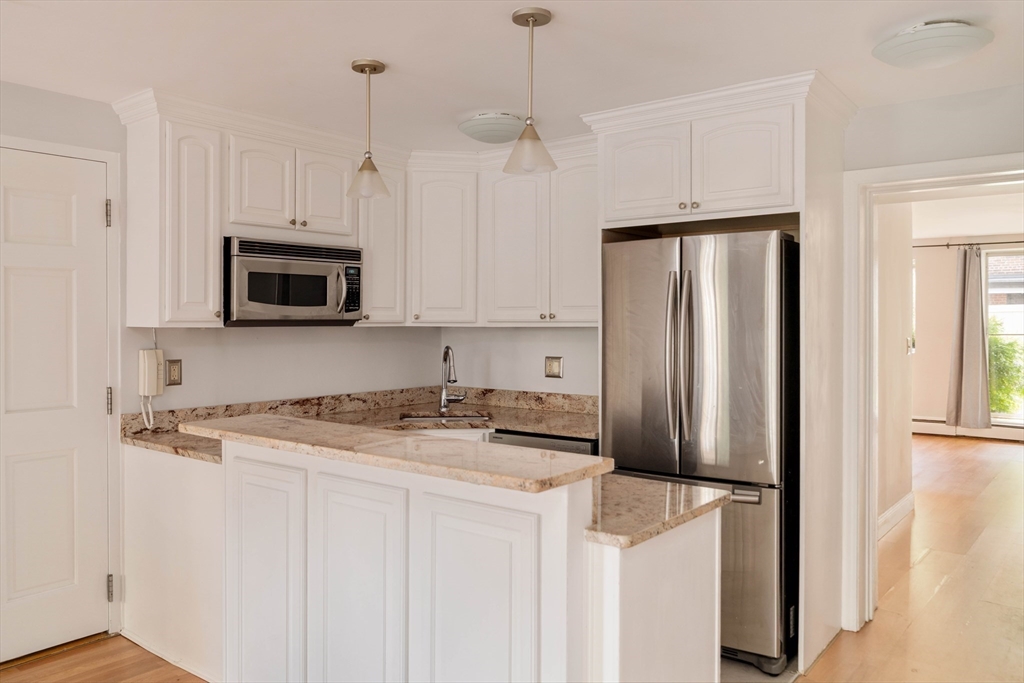 123 Sewall Avenue, Unit LC Brookline, MA 02446 - Photo 4 of 32 a kitchen with stainless steel appliances granite countertop a refrigerator a microwave a sink and white cabinets