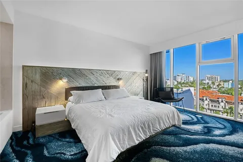 a bedroom with a bed mirror and window