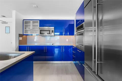 a kitchen with stainless steel appliances wooden cabinets a refrigerator and a sink