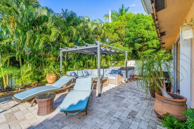 a view of a patio with chairs and potted plants