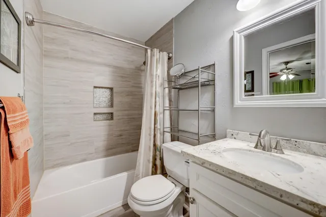 a bathroom with a granite countertop sink toilet and shower