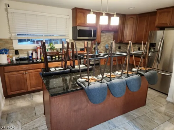 a kitchen with a table chairs and a refrigerator