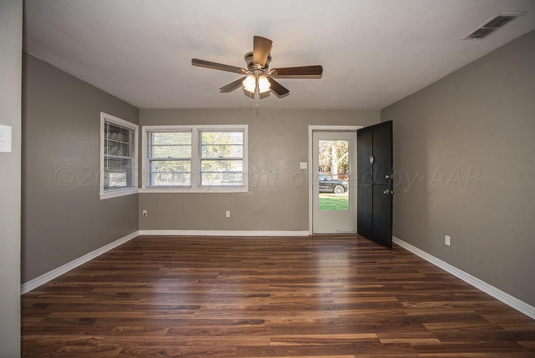 4008 Gables Street Amarillo, TX 79110 - Photo 2 of 15 a view of an empty room with wooden floor and a window