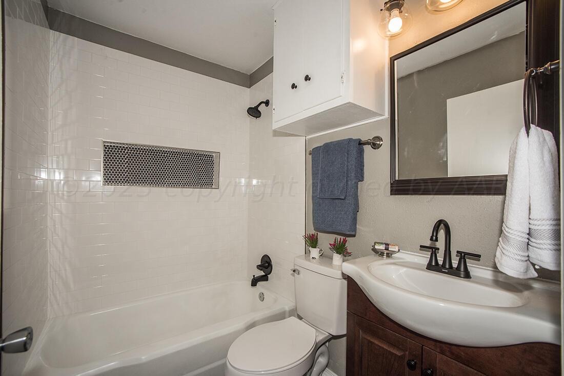 4008 Gables Street Amarillo, TX 79110 - Photo 9 of 15 a bathroom with a sink toilet a mirror and shower