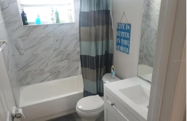 a white toilet sitting next to a bath tub