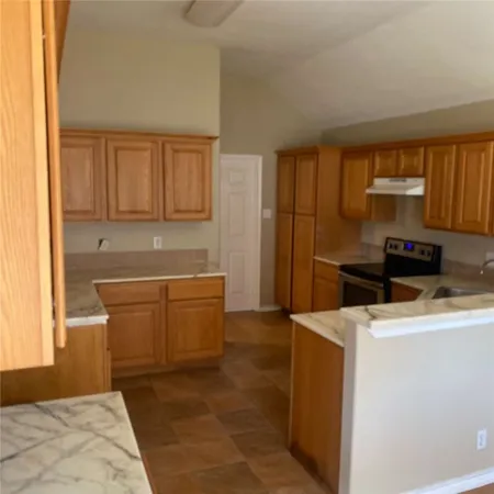 a kitchen with granite countertop cabinets stainless steel appliances and a sink