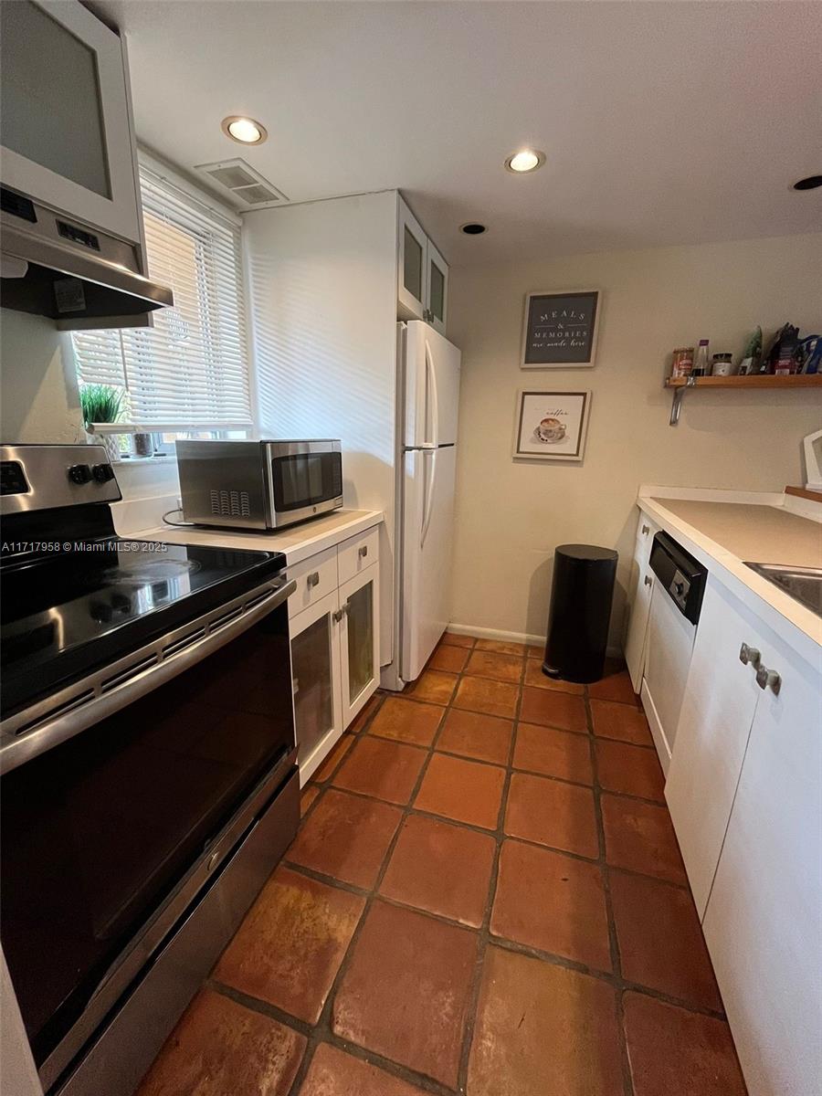 812 Southwest 9th St Circle, Unit 101 Boca Raton, FL 33486 - Photo 14 of 17 a kitchen with a stove a refrigerator and a sink
