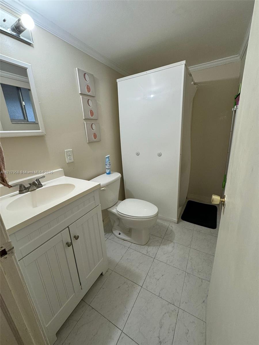 812 Southwest 9th St Circle, Unit 101 Boca Raton, FL 33486 - Photo 5 of 17 a bathroom with a sink a toilet and a mirror