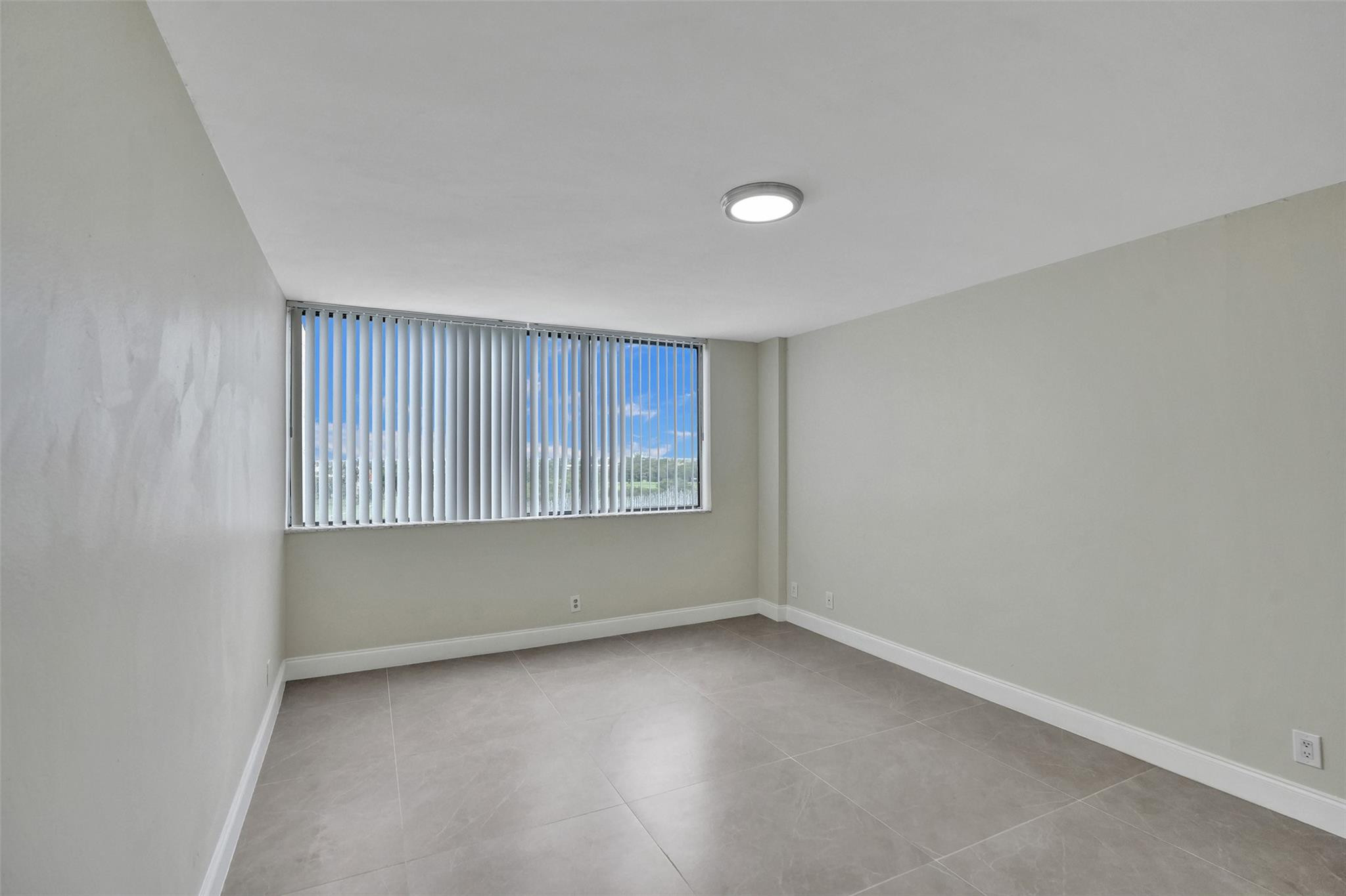 4222 Inverrary Boulevard, Unit 4810 Lauderhill, FL 33319 - Photo 29 of 63 an empty room with wooden floor and windows