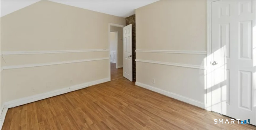 204 Main Street Sterling, CT 06377 - Photo 3 of 6 a view of an empty room with wooden floor and a window
