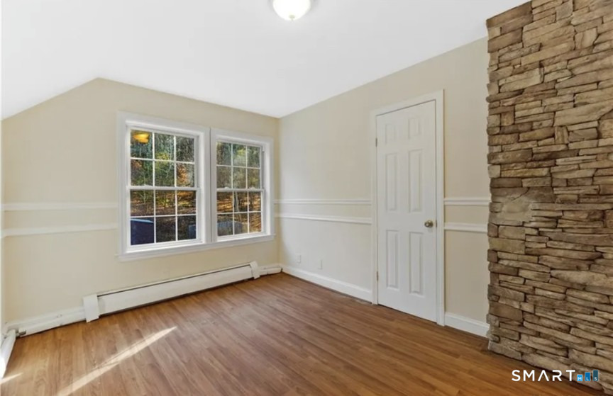 204 Main Street Sterling, CT 06377 - Photo 4 of 6 an empty room with wooden floor and windows