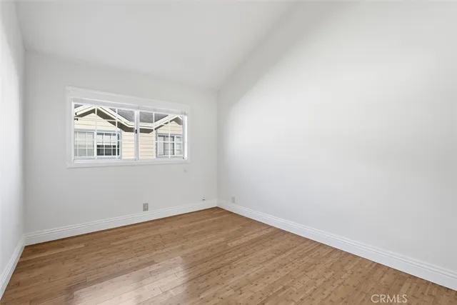 a view of a big room with wooden floor and windows