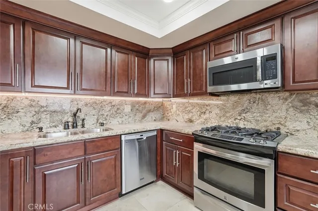 a kitchen with stainless steel appliances granite countertop a stove microwave and cabinets