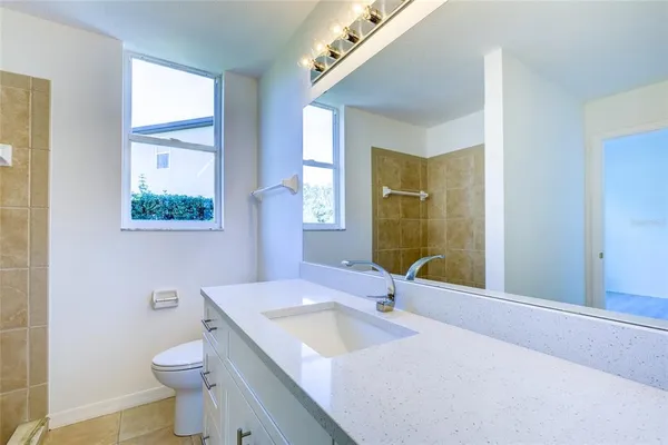 a bathroom with a double vanity sink toilet and a mirror